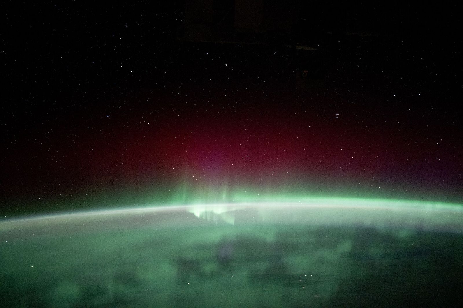 The aurora borealis spread across the Earth beneath the station